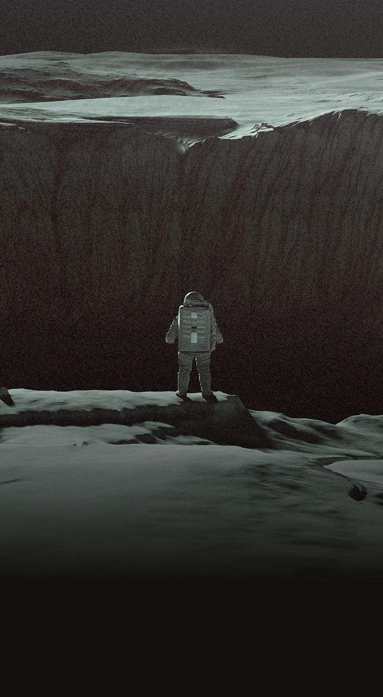 An astronaut in front of a large crater